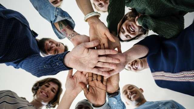 Diverse group of cancer patients holding hands in a circle