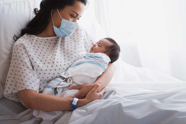母亲抱着刚出生的婴儿在医院里