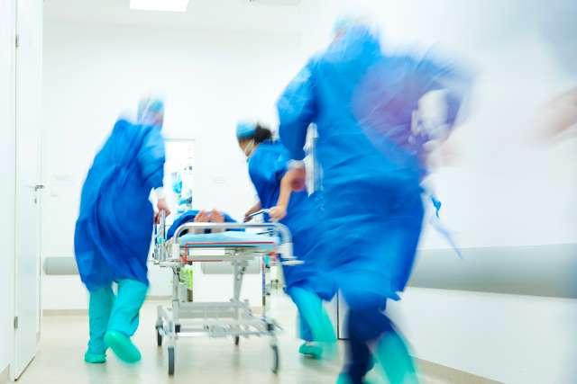 急诊室的工作人员推着轮床把病人送到急诊室