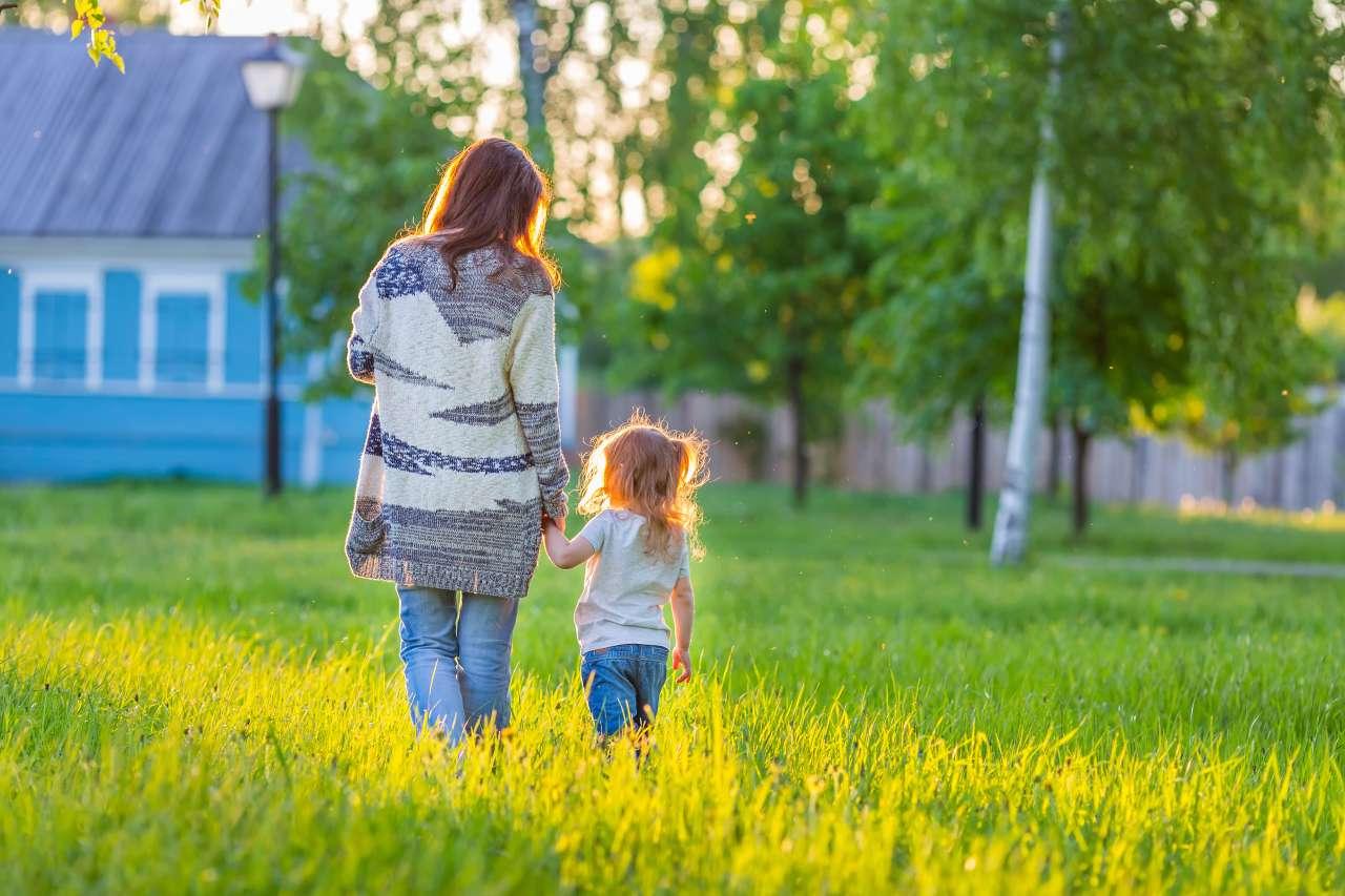 Mother and daughter holding hands and walking