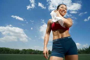 Woman using a towel to wipe off sweat